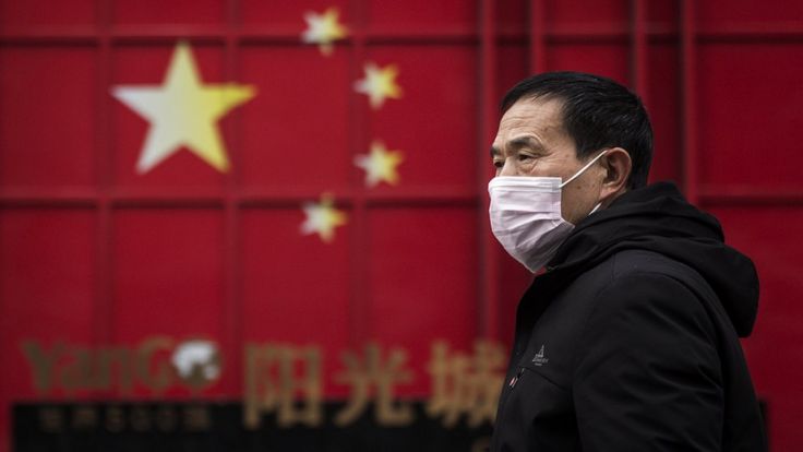 Homem anda de máscara em Wuhan