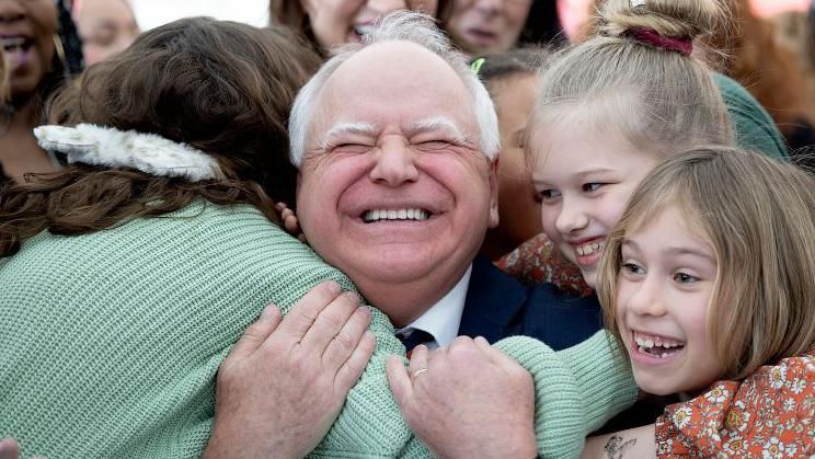 Minnesota Governor Tim Walz gets a huge hug from students at Webster Elementary in Minneapolis after he signed into law a bill that guarantees free school meals for every student in Minnesota's public and charter schools.