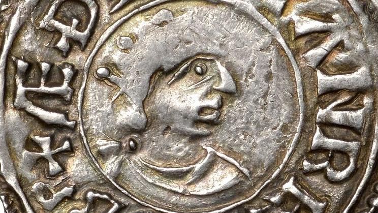 Close-up of a old silver coin with the head of a king
