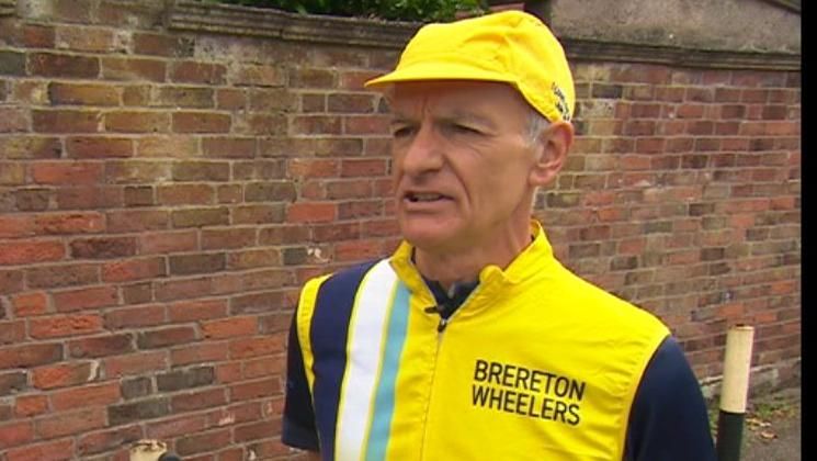 Phil Deakin standing and facing to the side. He is wearing a yellow cap and yellow jacket with the wording Brereton Wheelers. 