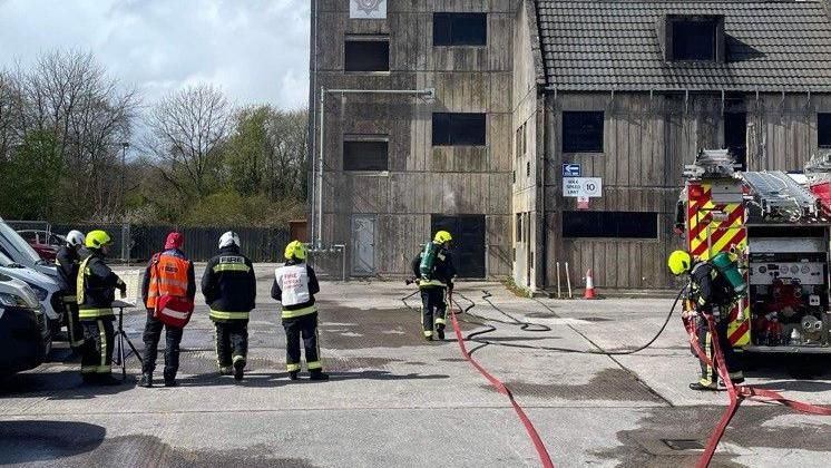 Several firefighters and other people involved in a fire safety training exercise.