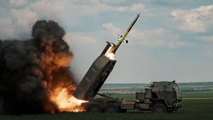 An image of a High Mobility Artillery Rocket Systems (Himars) being fired with some countryside in the background