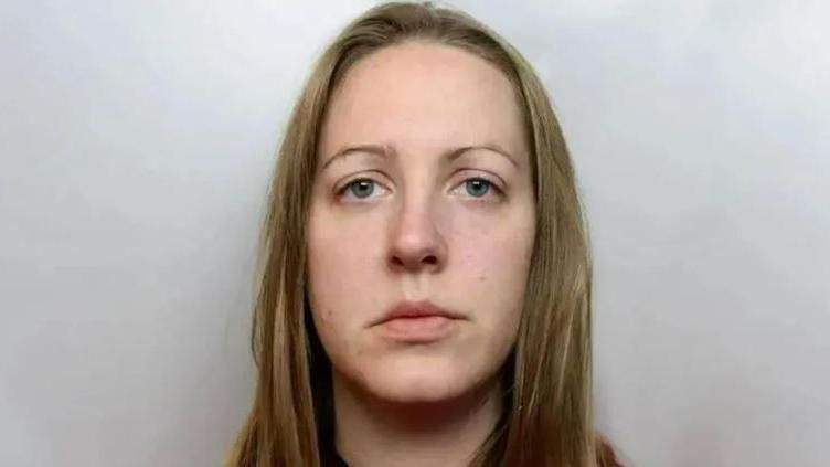 Lucy Letby stares at the camera, expressionless in a police mug shot photo. 