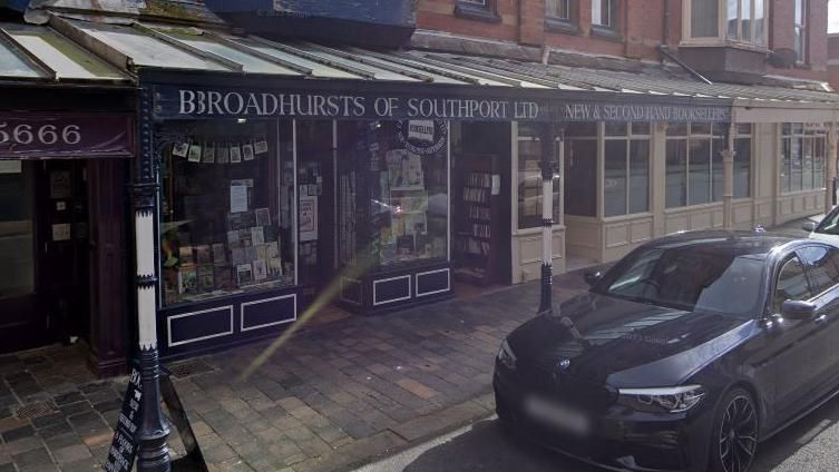 A Google street view image of the blue coloured front of Broadhursts of Southport, including the shop window and shop signs.
