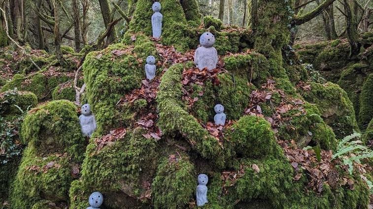 Sculptures of Japanese tree spirits in a woodland 