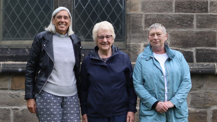 Three women standing outside a church 