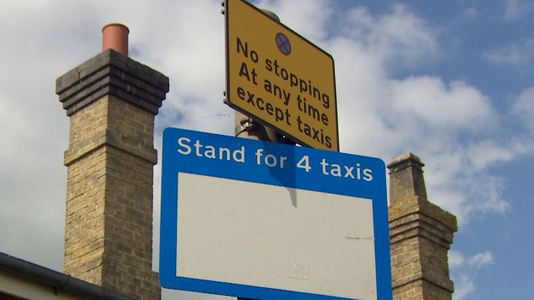 A blue 'Stand for taxis' sign can be seen with a sign added to the top of it which says 'No stopping at any time except taxis'