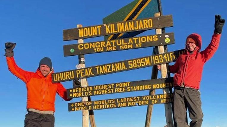 Sarah de Lagarde at the peak of Mount Kilimanjaro sign.