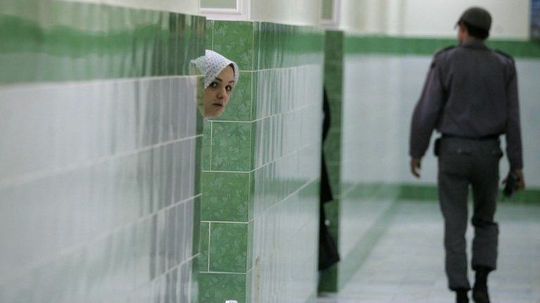 An inmate looks out the door of a cell at Tehran's Evin prison (13 June 2006)