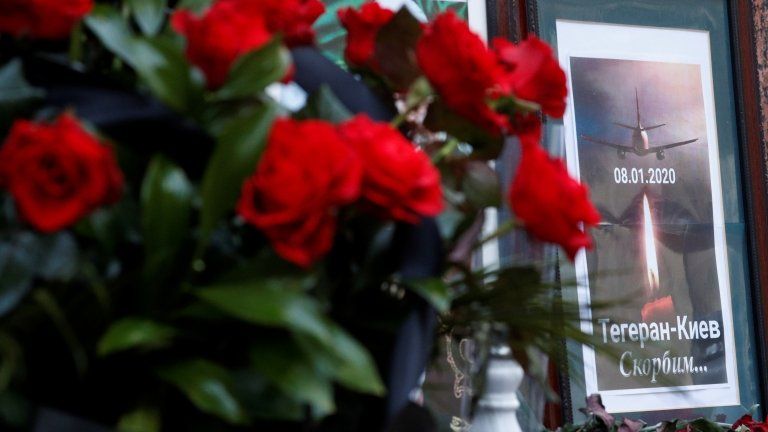 Flowers and a memorial poster are placed outside the Iranian Embassy in Ukraine