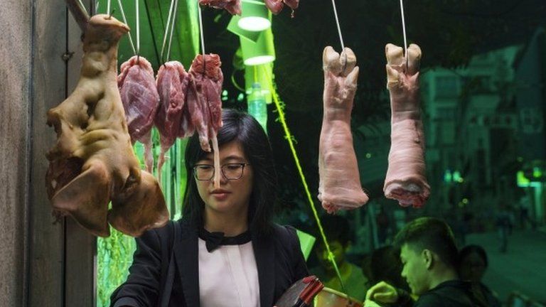 A woman buys meat from a butcher stall in Hong Kong, China, 22 March 2017