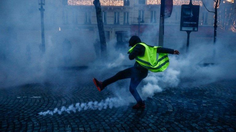 Protesters wearing yellow vests (gilets jaunes) clash with French riot police during a demonstration on the Champs-Elysées in Paris on December 15.