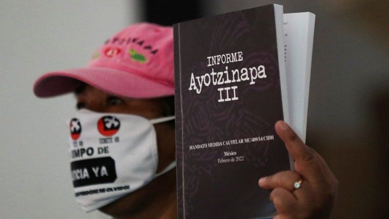 A relative of one of the 43 missing students of the Ayotzinapa teacher training college holds a book during a news conference as she reacts to the report presented by members of a team of international experts, in Mexico City, Mexico, March 29, 2022