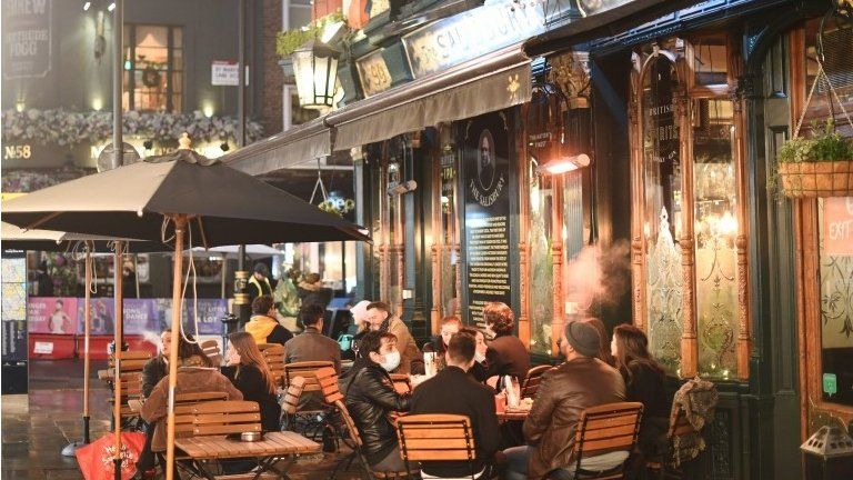 People sat outside a pub in the West End of London on Monday
