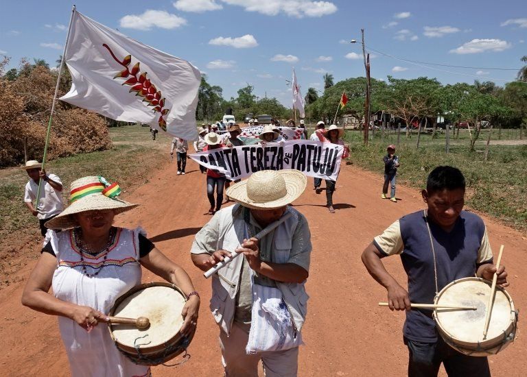 Protesters play instruments as they march to demand more action be taken to fight fires in Bolivia