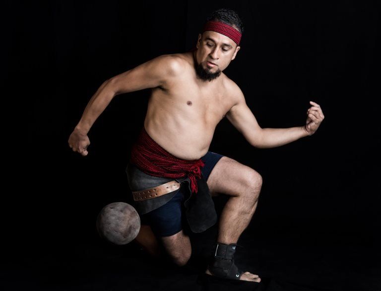 Mexican Enrique Villegas, player of a pre-Columbian ballgame called "Ulama" -in Nahuatl indigenous language- poses for a photograph hitting a "Ulamaloni" (solid rubber ball) with his hip, during a photo session at the FARO Poniente cultural centre in Mexico City on August 21, 2019