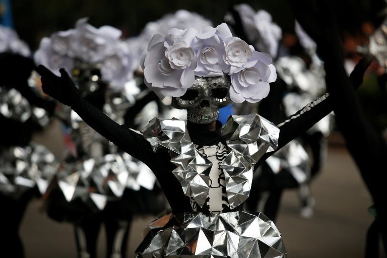 A participant wearing a skull mask performs during the annual Day of the Dead parade in Mexico City