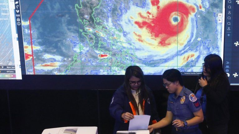 A monitoring team in the Philippines watch typhoon Mangkhut on screens
