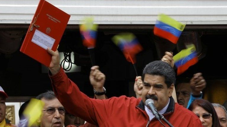 Venezuela"s President Nicolas Maduro holds a document with the details of a "constituent assembly" to reform the constitution during a rally at Miraflores Palace in Caracas, Venezuela May 23, 2017.