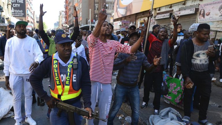 A police officer attempts to quell the violence in Johannesburg