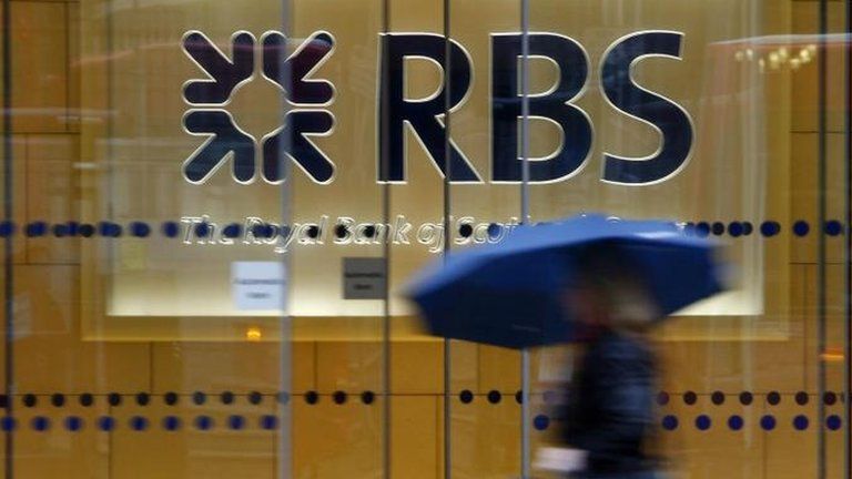 Woman walking past RBS sign