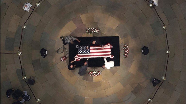 Workers clean the casket of the late US Senator John McCain as he lies in state in the US Capitol Rotunda on 31 August 2018 in Washington