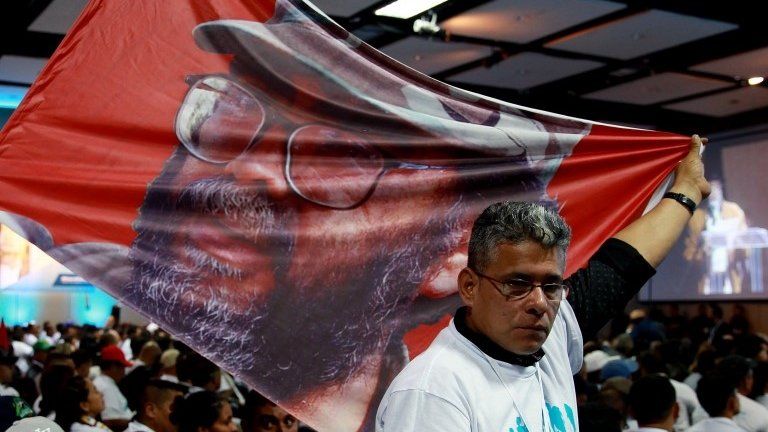 epa06167344 A man shows a flag with the picture of late FARC leader Guillermo Leon Saenz, AKA "Alfonso Cano", during the FARC-EP"s National Congress in Bogota, Colombia, 27 August 2017