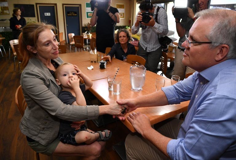 Scott Morrison meets a woman in child in Picton, New South Wales, in front of media representatives