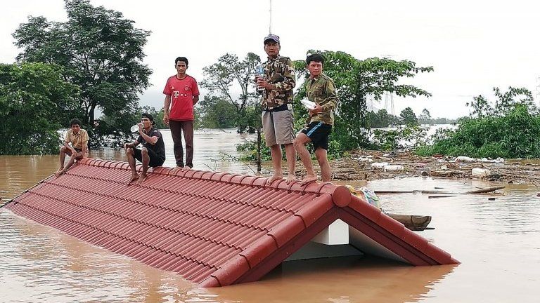 Lao villagers are stranded on a roof of a house after they evacuated floodwaters after the Xe Pian Xe Nam Noy dam collapsed in a village near Attapeu province
