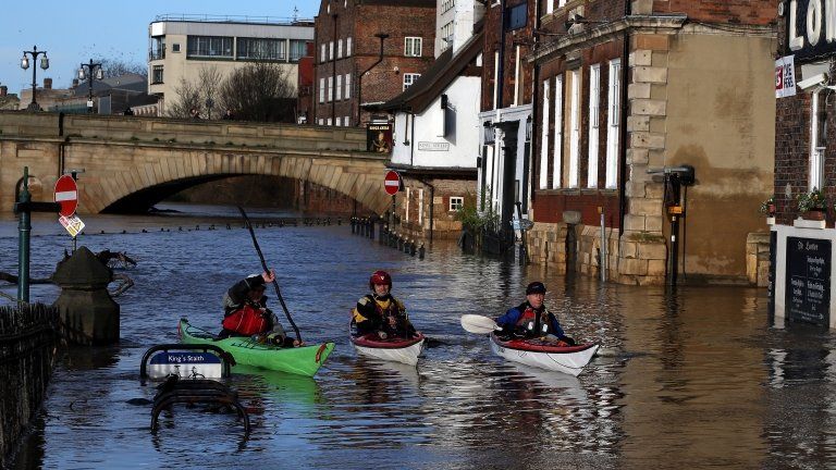 Canoeists check out buildings in flooded York on December 31, 2015