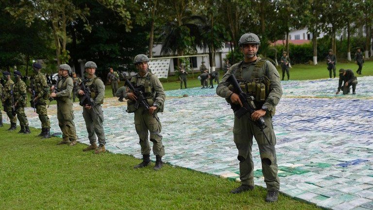 This handout picture released by Colombia"s Presidency shows anti-narcotics police members guarding over 12 ton of cocaine on November 8, 2017 in Apartado, Antioquia, Colombia.