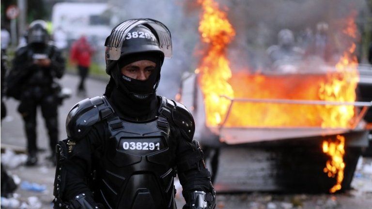 A police officer in riot gear looks on during clashed with demonstrators during a protest organized in reaction to the killing of lawyer Javier Ordonez, in Bogota, Colombia, 09 September 2020.