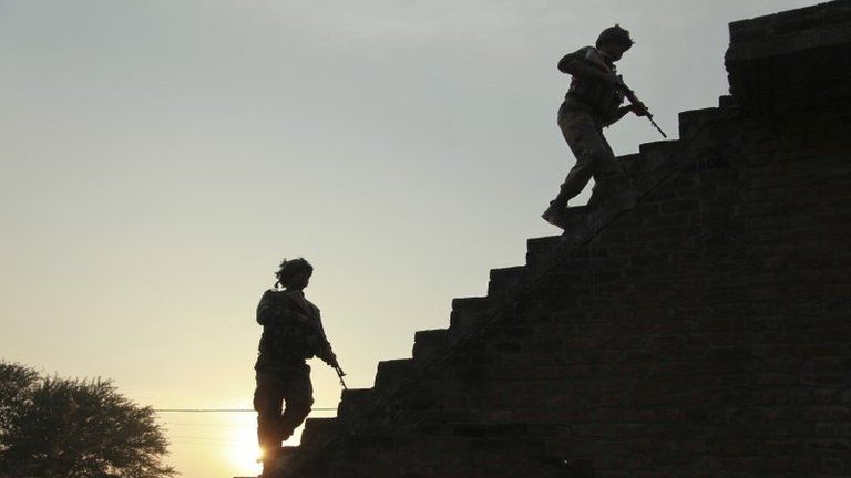 Indian army soldiers climb up the stairs of a residential building outside the Indian air force base in Pathankot, India, Sunday, Jan. 3, 2016.
