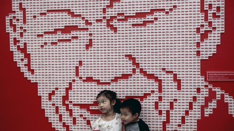 Two young children pose for a photograph against a mural made out of nearly 5,000 Singapore country erasers forming the likeness of Mr Lee Kuan Yew, during a tribute event in Singapore, 20 March 2016.