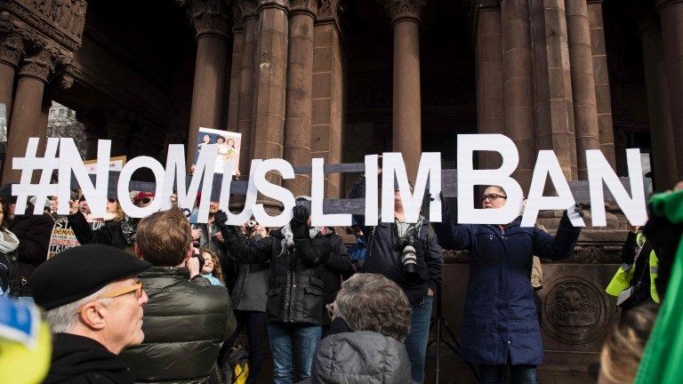Protesters hold up words reading #NoMuslimBan inBoston, Massachusetts, on 29 January 2017