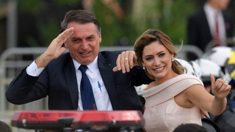 Brazil's President-elect Jair Bolsonaro (L) gestures next to his wife Michelle Bolsonaro as the presidential convoy heads to the National Congress for his swearing-in ceremony, in Brasilia on January 1, 2019