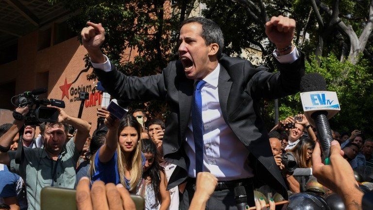 Venezuelan opposition leader Juan Guaido shouts surrounded by journalists on his way to the National Assembly, in Caracas, on January 7, 2020
