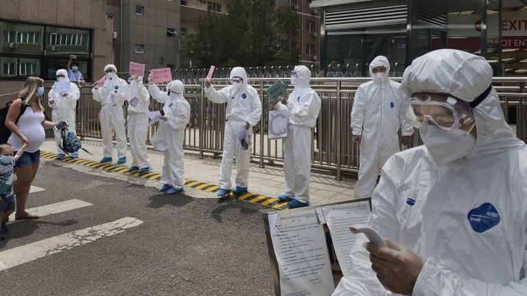 Men in protective clothing conduct coronavirus tests in Beijing