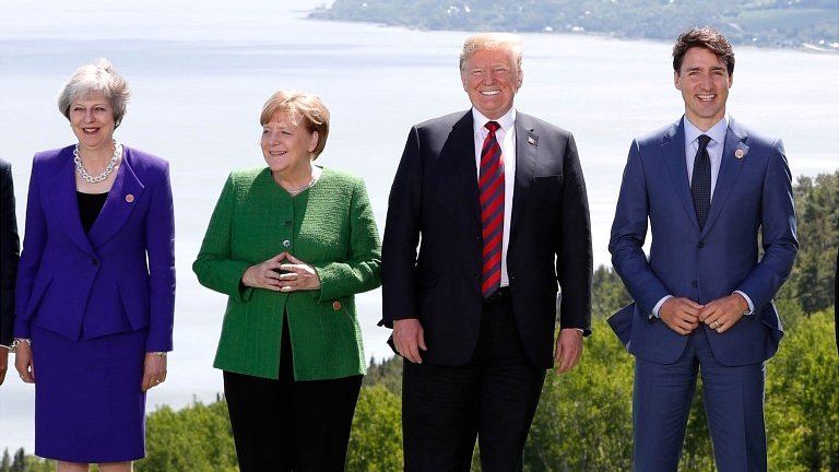 Britain's Prime Minister Theresa May, Germany's Chancellor Angela Merkel, US President Donald Trump and Canada's Prime Minister Justin Trudeau pose during a family photo at the G7 Summit in the Charlevoix city of La Malbaie, Quebec, Canada, on 8 June 2018