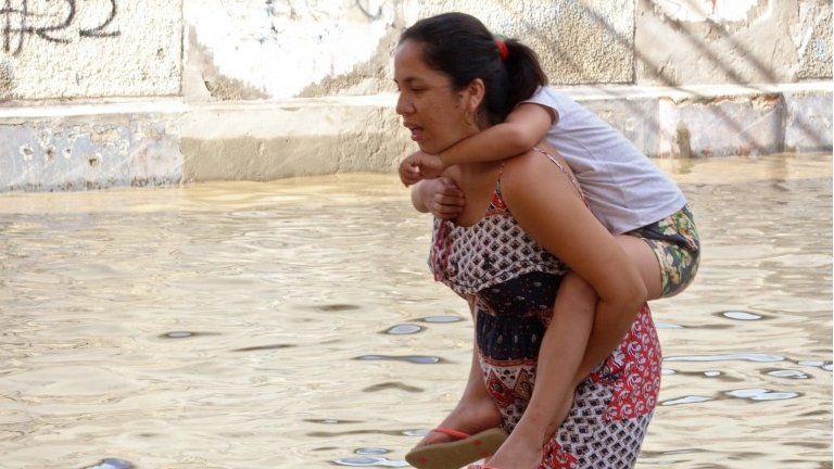 Residents in the city of Piura, 1,000 kilometres north of Lima, wade through water on the streets on March 27, 2017, after nearly 15 hours of rain caused the Piura River to overflow, flooding neighbourhoods in most of the city.
