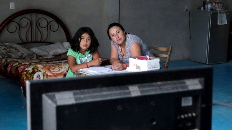 Karina Fuentes helps her daughter Julieta, 7, during a televised class as millions of students returned to classes virtually after schools were ordered into lockdown in March, due to the coronavirus disease (COVID-19) outbreak, in Chilcuautla, Hildalgo state, Mexico August 24, 2020.