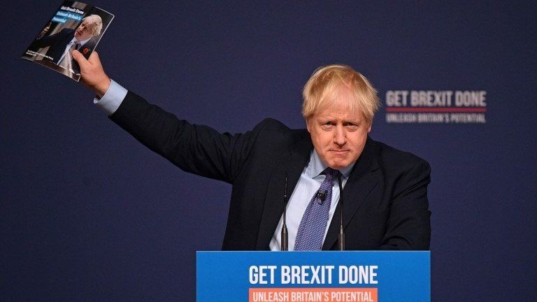 Boris Johnson waving manifesto