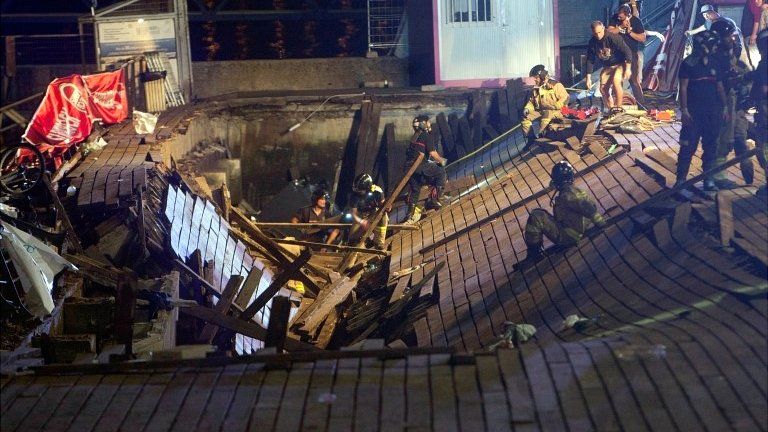 Several firefighters search for victims after several dozens people fell into the sea when a wooden gateway collapsed during a concert in Vigo, north-western Spain, on 12 August 2018