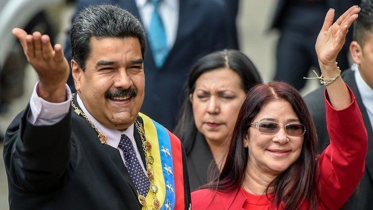 Venezuelan President Nicolas Maduro and his wife, Cilia Flores wave to supporters before the ceremony