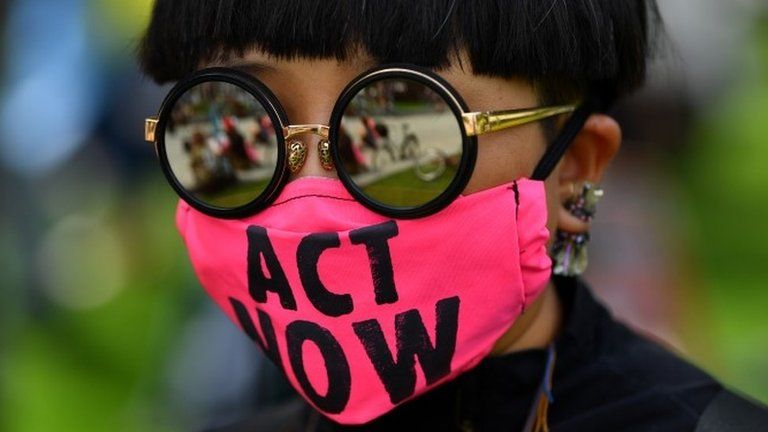 Protester wearing an "act now"