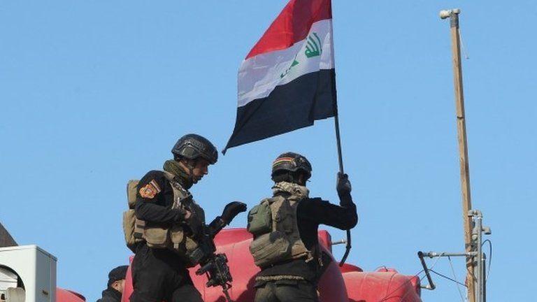 Iraqi counter-terrorism troops raise national flag on building in government compound in Ramadi (28/12/15)