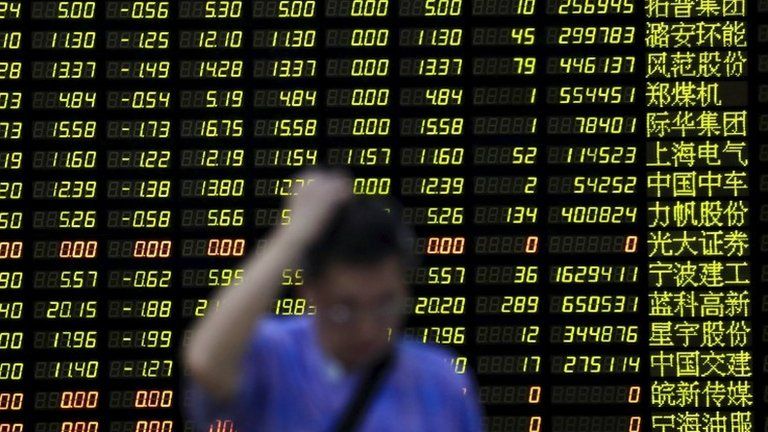 An investor stands in front of an electronic board in Shanghai