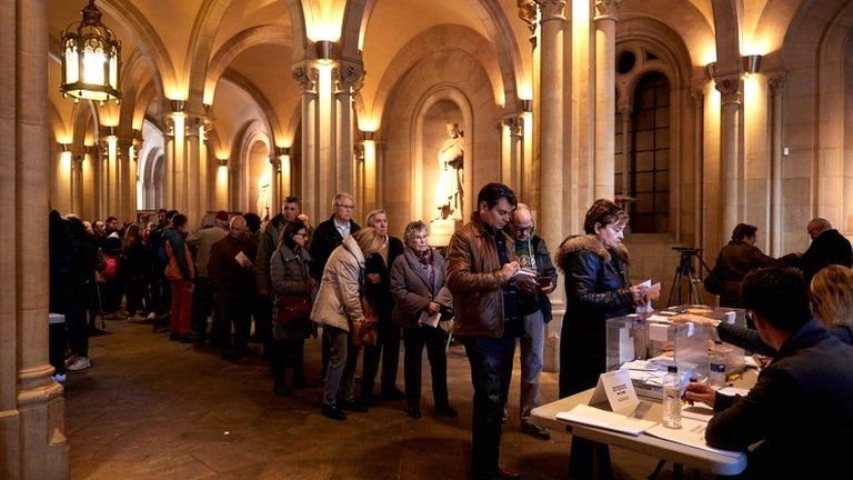 People stand in a queue to cast their vote at a polling station in Barcelona on 10 November 2019