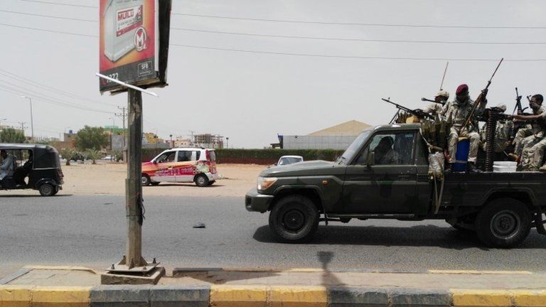 Sudanese security forces drive through a main road linking Omdurman with its twin city Khartoum on 9 JunE