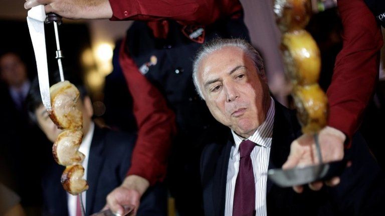 Brazil's President Michel Temer eats barbecue in a steak house after a meeting with ambassadors of meat importing countries of Brazil, in Brasilia